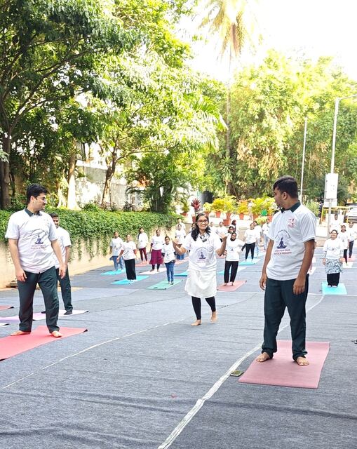Participants in yoga pose on mats along the street
