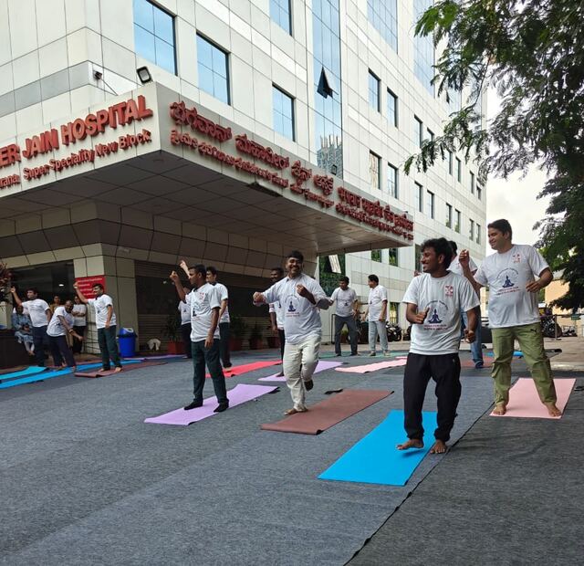 Participants doing a balance pose outside the hospital entrance