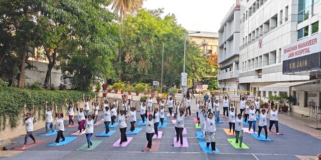 Group in a lunge yoga pose on the street