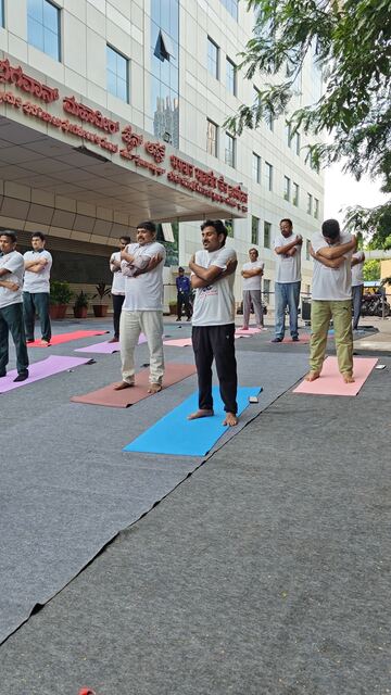 Group doing a crossed-arm stretch outside the hospital entrance